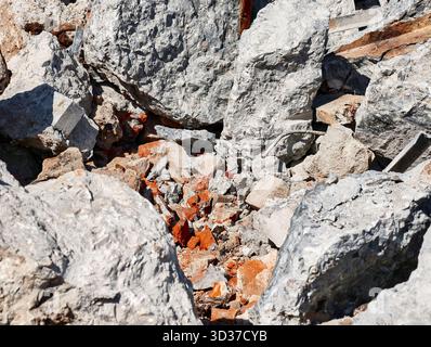 Schutt und Trümmer, die nach Abbrucharbeiten an einem sonnigen Tag in der Stadt auf einer Baustelle verstreut wurden Stockfoto