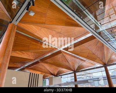 Moderne Deckenarchitektur aus Holz mit komplexen geometrischen Fächerpaneelen, freiliegenden Balken und natürlichem Licht durch Glasoberlichter in Auckland, N Stockfoto