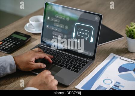 Geschäftsmann, der die KI-Chatbot-Schnittstelle auf einem Laptop für die Unterstützung von Chatbot-Technologie im digitalen Contact Center nutzt Stockfoto