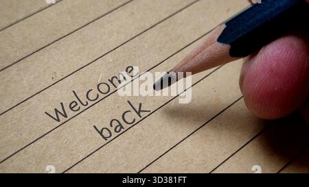 Begrüßungsworte, geschrieben auf liniertem Vintage-Papier mit Hand haltendem Bleistiftgrußkonzept Stockfoto