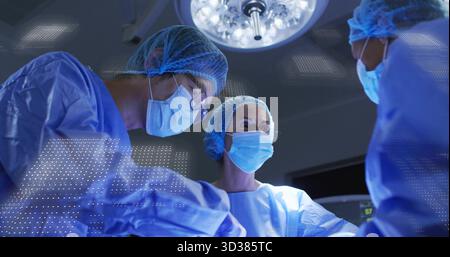 Bedienpersonal trägt Scheuerstellen, die in ODER, mit Vorhängen, Ablage und Monitor unter Deckenleuchte arbeiten Stockfoto