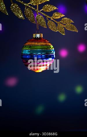Weihnachtskugel Regenbogenfarben hängen an goldenen Zweigen Stockfoto