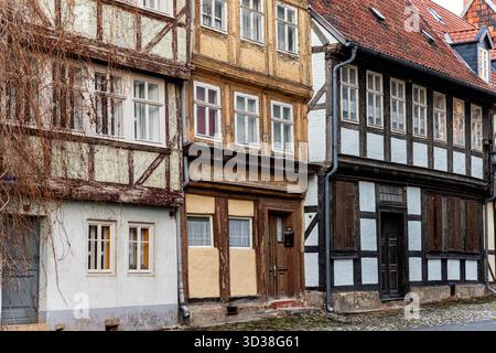 Alte Holzhäuser mit abblätternder Farbe und verblassten Farben stehen in der Nähe einer engen Kopfsteinpflasterstraße. Ihre verwitterten Oberflächen und rustikal Stockfoto