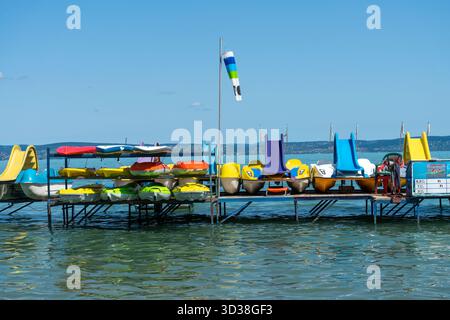 Bunte Tretboote und Kajaks stehen auf einem Pier am Balaton, Ungarn, bereit für Sommererholung auf dem Wasser. Stockfoto
