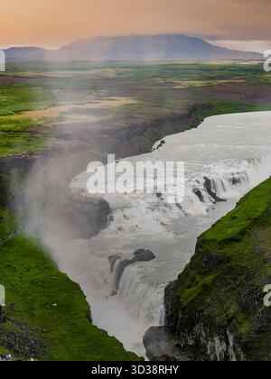 Ein gestufter Wasserfall durchschneidet den Basaltschlucht bei Gullfoss, Island, bei Sonnenuntergang Stockfoto