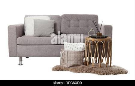 Stilvolles Sofa mit Kissen, Couchtisch und Teppich isoliert auf weiß Stockfoto