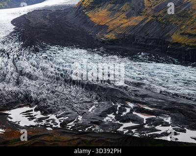Luftgletscherzunge mit Aschestreifen und Schmelzwasser in Island Stockfoto