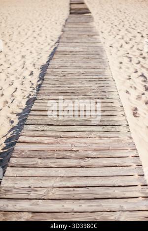 Eine Promenade, die über einen Sandstrand führt Stockfoto