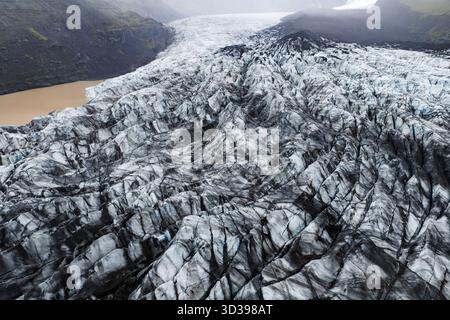 Luftgletscher mit Aschestreifen und einem Gletschersee in Island Stockfoto