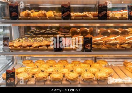 Kuala Lumpur, Malaysia - November 1,2025 : Eine Bäckerei mit einer großen Auswahl an Gebäck in einer gut beleuchteten Vitrine. Stockfoto