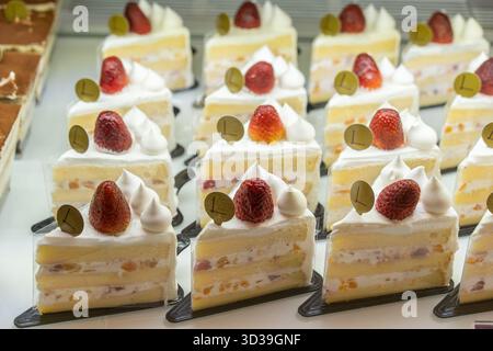 Kuala Lumpur, Malaysia - 1. November 2025 : verschiedene Erdbeercremekuchenscheiben werden im Bäckereikasten zum Verkauf angeboten. Stockfoto