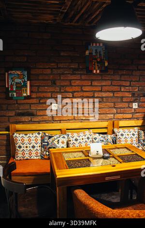 Kerze an einem Tisch im Freien in einem Restaurant im Winter, gemütliche Atmosphäre, selektiver Fokus, Bokeh-Café mit Kissen und Holzwand mit U-Boot Stockfoto