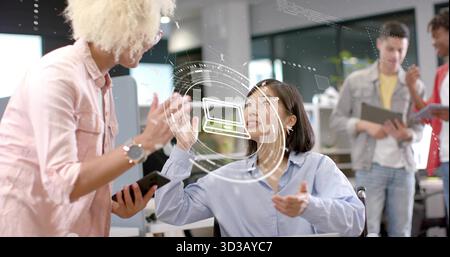 Sitzende Frau in blauem Hemd, die im modernen Büro zur holografischen Laptop-Ikone schreitet Stockfoto