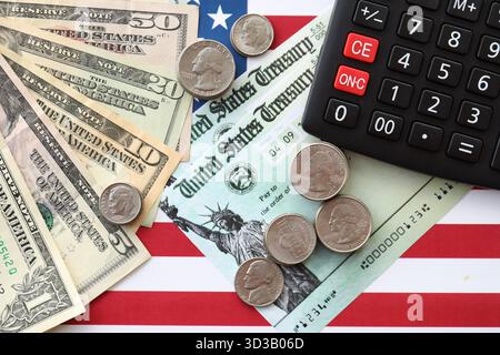 US-Dollar-Geldscheine und Taschenrechner auf amerikanischer Flagge Nahaufnahme. Geldinvestitionskonzept und Steuerzahlung Stockfoto