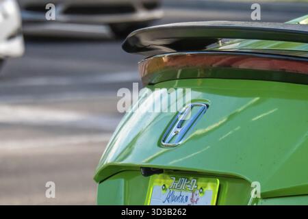 Calgary, Alberta, Kanada. Juni 2025. Eine Nahaufnahme des Hecks eines leuchtend grünen Honda Civic mit markantem Spoiler und personalisiertem Alberta-Führerschein Stockfoto