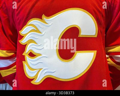 Calgary, Alberta, Kanada. April 2025. Nahaufnahme eines Calgary Flames Trikots mit einem großen weißen C-Logo mit Flammendetails in Gelb und Rot Stockfoto