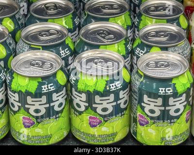 Calgary, Alberta, Kanada. April 2025. Eine Nahaufnahme zeigt mehrere Dosen Haitai Grape Bon Bon Drink mit grüner Verpackung und Traubenillustratio Stockfoto