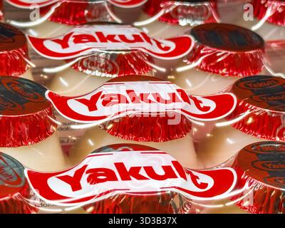 Calgary, Alberta, Kanada. April 2025. Nahaufnahme vieler Yakult-Flaschen mit rot-weißen Folienoberflächen mit dem Markenlogo Stockfoto