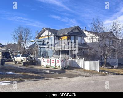 Calgary, Alberta, Kanada. März 2025. Ein Wohnhaus, das renoviert wird und die Arbeiter neue Abstellgleise anbauen. Müllcontainer und Lkw sind vorhanden, indi Stockfoto