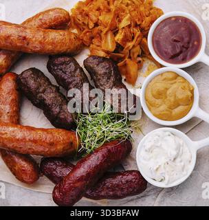 Speisen, Bier, gegrillte Würstchen mit gedünstetem Kohl und Saucen Stockfoto