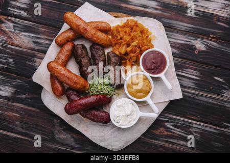 Speisen, Bier, gegrillte Würstchen mit gedünstetem Kohl und Saucen Stockfoto