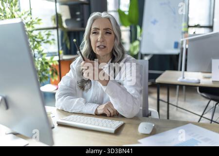 Videokonferenz. Geschäftsfrau hat eine Videokonferenz und sieht involviert aus Stockfoto