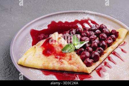 Essen, Pfannkuchen mit Kirschen auf dem Teller von oben Stockfoto