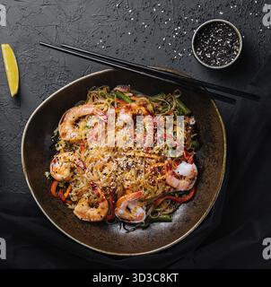 Lebensmittel, Nudeln mit Gemüse und Garnelen in einer schwarzen Schüssel anbraten Stockfoto