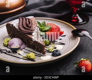 Essen, Brownie-Kuchen mit einer Schaufel Vanilleeis und Erdbeeren Stockfoto