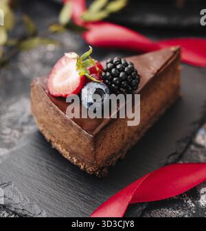 Essen, leckerer Schokoladenkuchen dekoriert mit frischen Beeren auf Holztisch Stockfoto