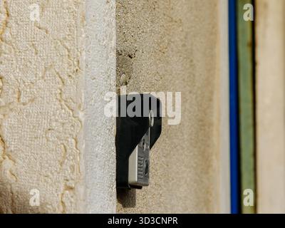Wandmontierte Sicherheits-Türklingelkamera auf strukturierter Oberfläche. Stockfoto