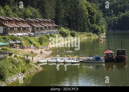 Zagorze Slaskie, Polen - August 2020 : Wasserfahrradboote und kleine Yachten vor Ferienhäusern und Bungalows am Ufer von Zagorze Slaskie Stockfoto