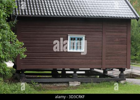 Traditionelles rotes Holzhaus in skandinavischer Landschaft – ländliche nordische Architektur im Sommer und Winter Stockfoto