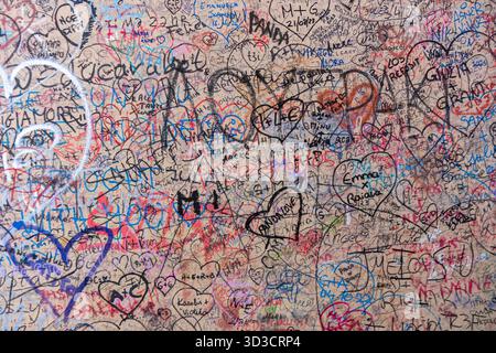 Italien, Verona - 1. Oktober 2025: Liebesinschriften an der Wand von Julias Haus (Casa di Giulietta), bunte Botschaften und Namen von Besuchern Stockfoto