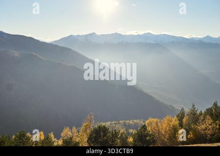 Sonnenstrahlen über Herbstwald und Bergrücken in Karachay-Tscherkessia, Nordkaukasus Stockfoto