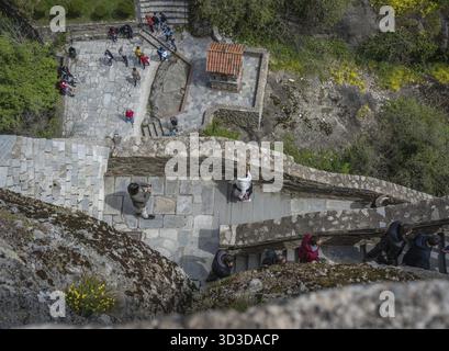 Meteora, Griechenland - April 2019: Menschen klettern auf in einen Felsen gehauene Treppen zum Great Meteoron Kloster in Meteora, Griechenland Stockfoto