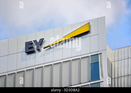 London, Vereinigtes Königreich - 18. Mai 2023: Blaue und gelbe EY-Schilder am Eingang ihres Büros in Canary Wharf. Es handelt sich um ein britisches Unternehmen für professionelle Dienstleistungen, Stockfoto