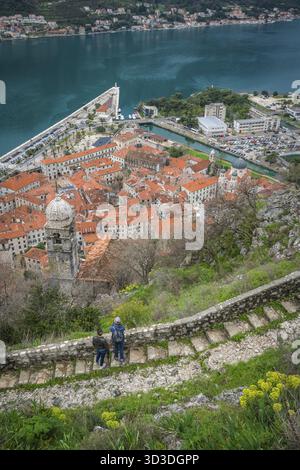 Kotor, Montenegro - April 2018: Zwei Touristen bewundern die Aussicht von der steinigen Trail und Schritte zur Festung oberhalb der Stadt Kotor Kotor Stockfoto