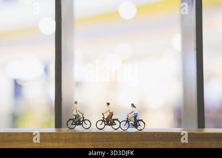 Miniatur-Leute : Reisende mit Fahrrad auf Holzbrücke Stockfoto