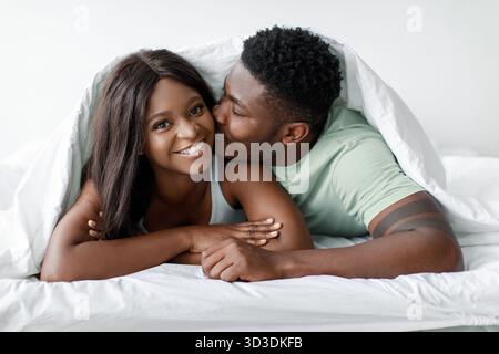 Paare genießen intime Momente zusammen im Bett während des Morgenlichts Stockfoto