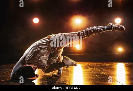 Junger Mann tanzt im Club mit roten Lichtern. Leuchtende Kontrastfarben Stockfoto