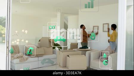 Paar hängende Bilderrahmen im Wohnzimmer mit Kartonschachteln und grünen Symbolen, Kopierraum Stockfoto