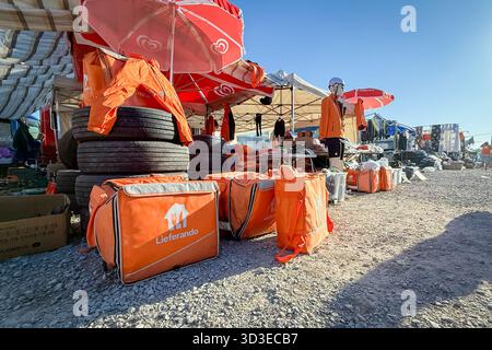 SABAC, SERBIEN - 20. SEPTEMBER 2025: Lieferando-Lieferausrüstung aus zweiter Hand auf einem Flohmarkt in Sabac ausgestellt. Isolierte Rucksäcke, Jacken sind angeordnet Stockfoto