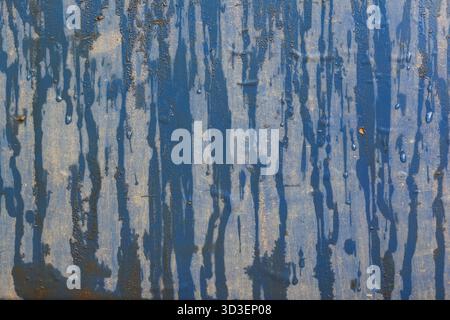 Abstrakter blauer Grunge-Texturhintergrund mit tropfenden Farbstreifen. Verwitterte und alte Oberfläche, die ein stimmungsvolles, industrielles Muster erzeugt und Anzeichen von DE zeigt Stockfoto