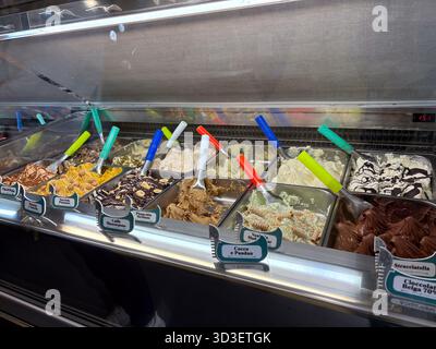 Eis-Aromen in einer gekühlten Vitrine in der Gelateria Gondola in Chatswood, Sydney, Australien. Verschiedene bunte Schaufeln mit unterschiedlichen Belägen Stockfoto