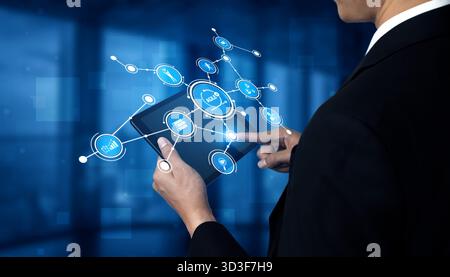 Ein Geschäftsmann im Anzug interagiert mit einer digitalen Schnittstelle auf einem Tablet und stellt Technologie, Konnektivität und moderne Kommunikation in einem Unternehmen vor Stockfoto