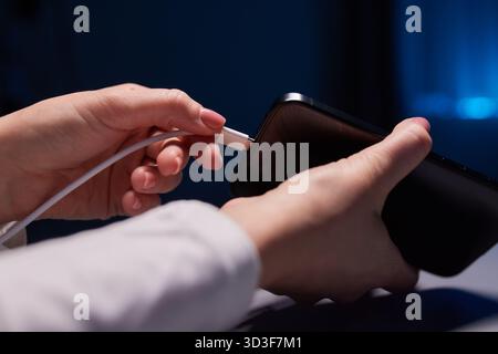 Handaufladung bei weiblicher Hand lädt Ihr Telefon auf. Nahaufnahme USB Typ-C Stockfoto