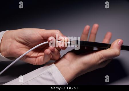 Handaufladung bei weiblicher Hand lädt Ihr Telefon auf. Nahaufnahme USB Typ-C Stockfoto