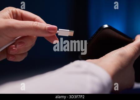Handaufladung bei weiblicher Hand lädt Ihr Telefon auf. Nahaufnahme USB Typ-C Stockfoto