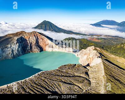 Aus der Vogelperspektive auf die Felsenklippe am Kawah Ijen Vulkan mit türkisfarbenem Schwefelwassersee bei Sonnenaufgang. Fantastischer Blick auf die Naturlandschaft in Ost-Java, Indonesien. Natu Stockfoto